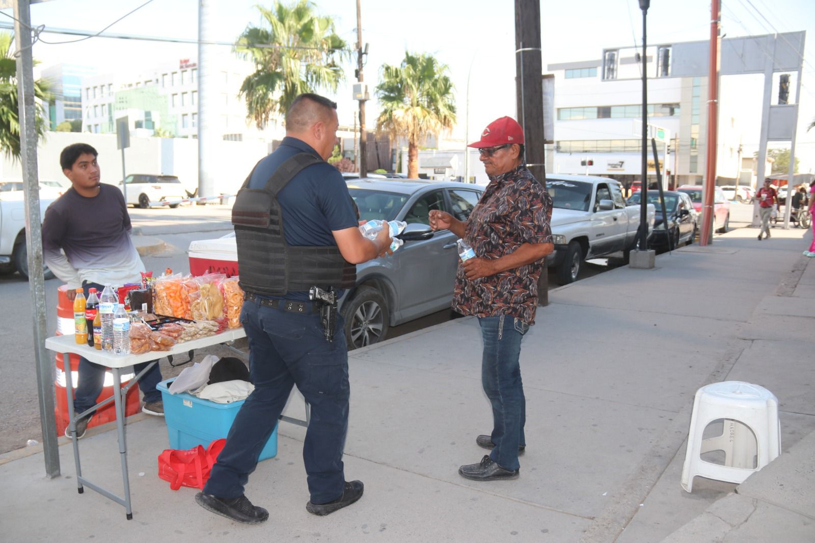 Apoyan policías con reparto de agua embotellada a personas en hospitales.